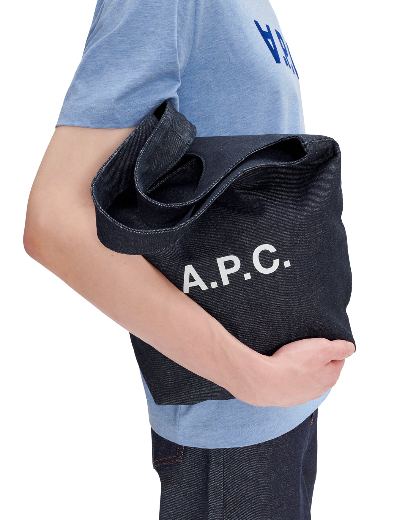 Tote bag A.P.C. Ninon Small denim indigo porté à la main profil gauche